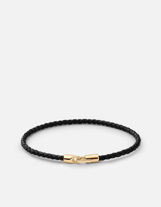 Miansai Cruz bracelet in braided black leather with a gold vermeil clasp arranged in an oval