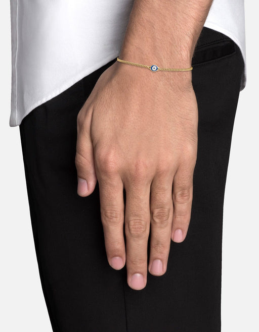 Miansai single evil eye bracelet in gold vermeil with a blue and white enamel centerpiece worn on the wrist
