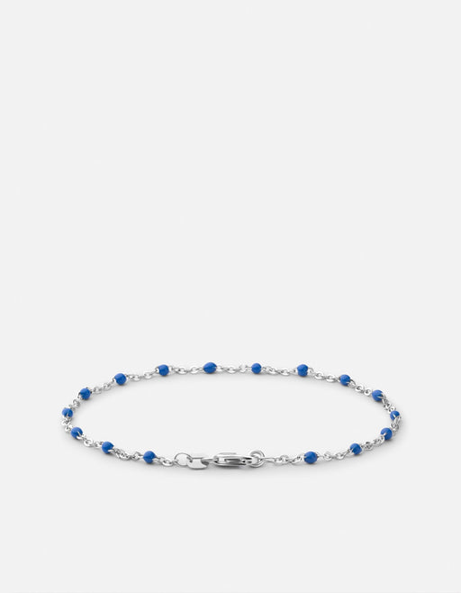 Miansai Ciro chain bracelet in polished sterling silver with blue enamel spheres and clasp displayed in an oval shape