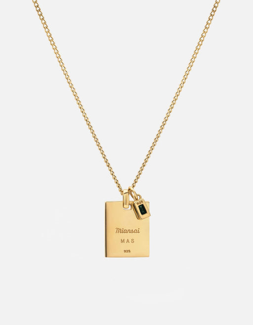 Miansai Lineage pendant necklace in gold vermeil with a rectangular engraved tag and small green stone charm on a fine chain