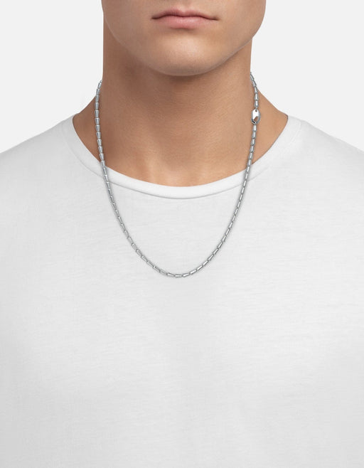 Miansai Elara chain necklace in polished sterling silver with tapered alternating links worn at the neck over a white shirt