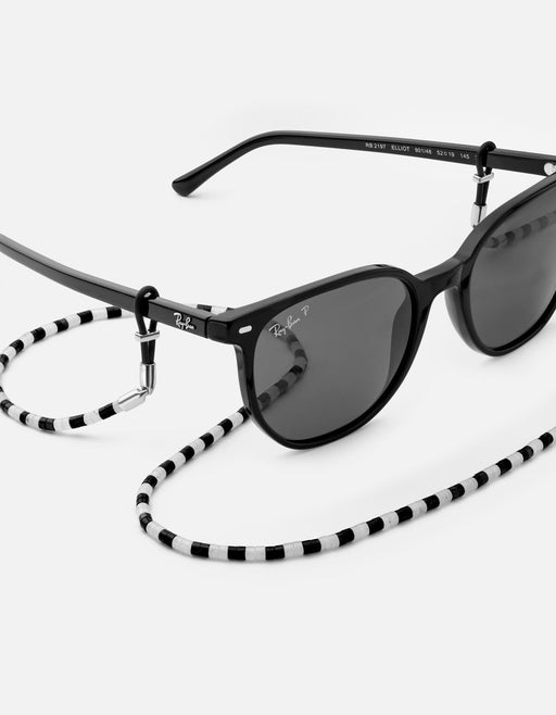 Miansai Kai sunglass safety with alternating black and white onyx beads and sterling silver hardware paired with black sunglasses
