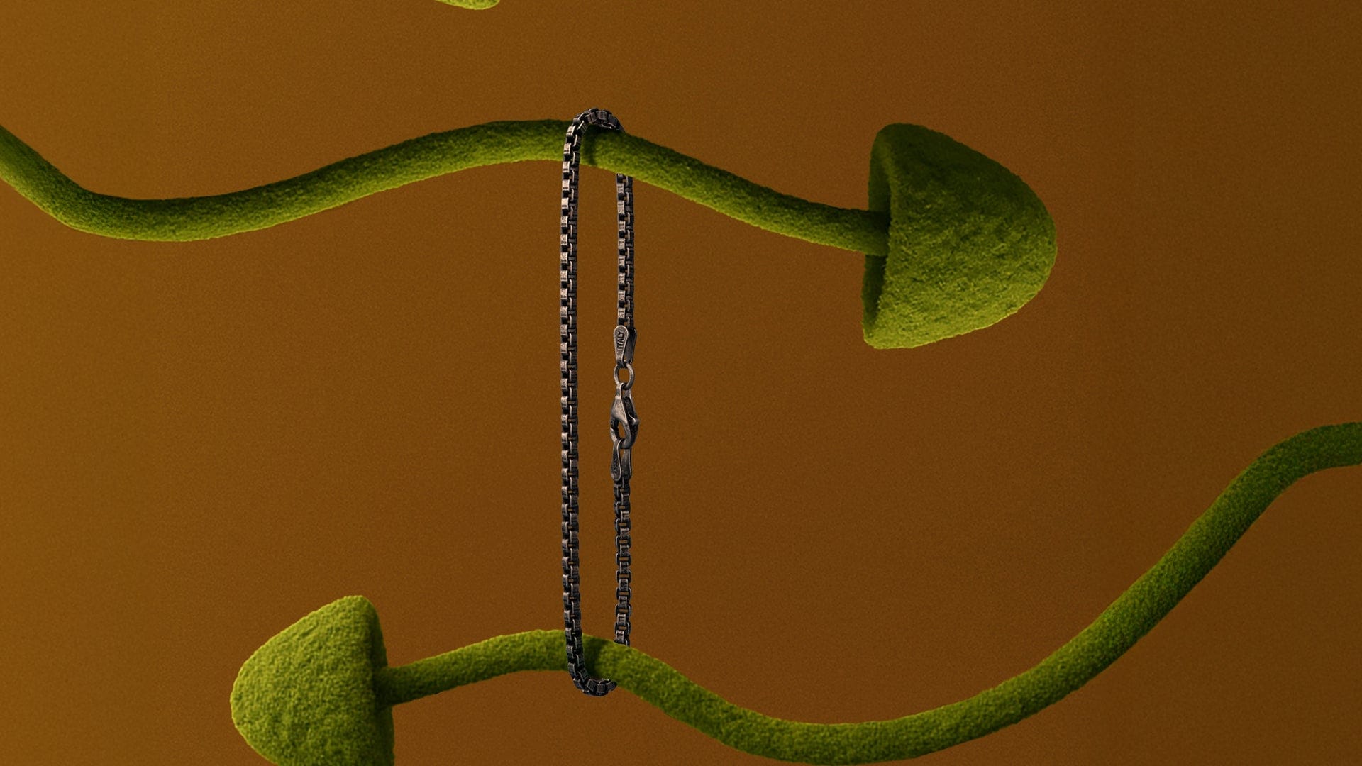 Green abstract sculpture with a chain on a brown background