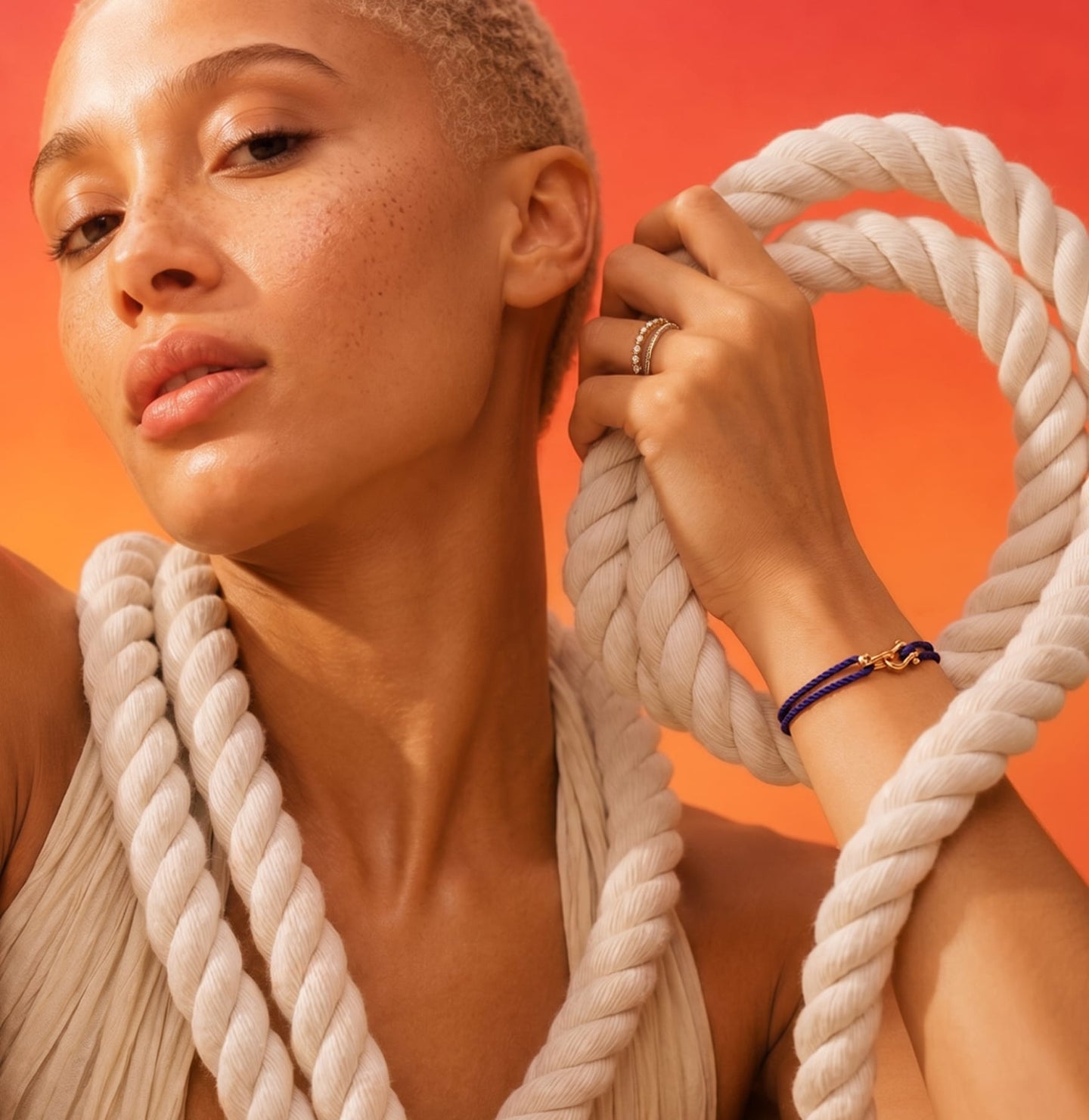 Woman holding rope against an orange background