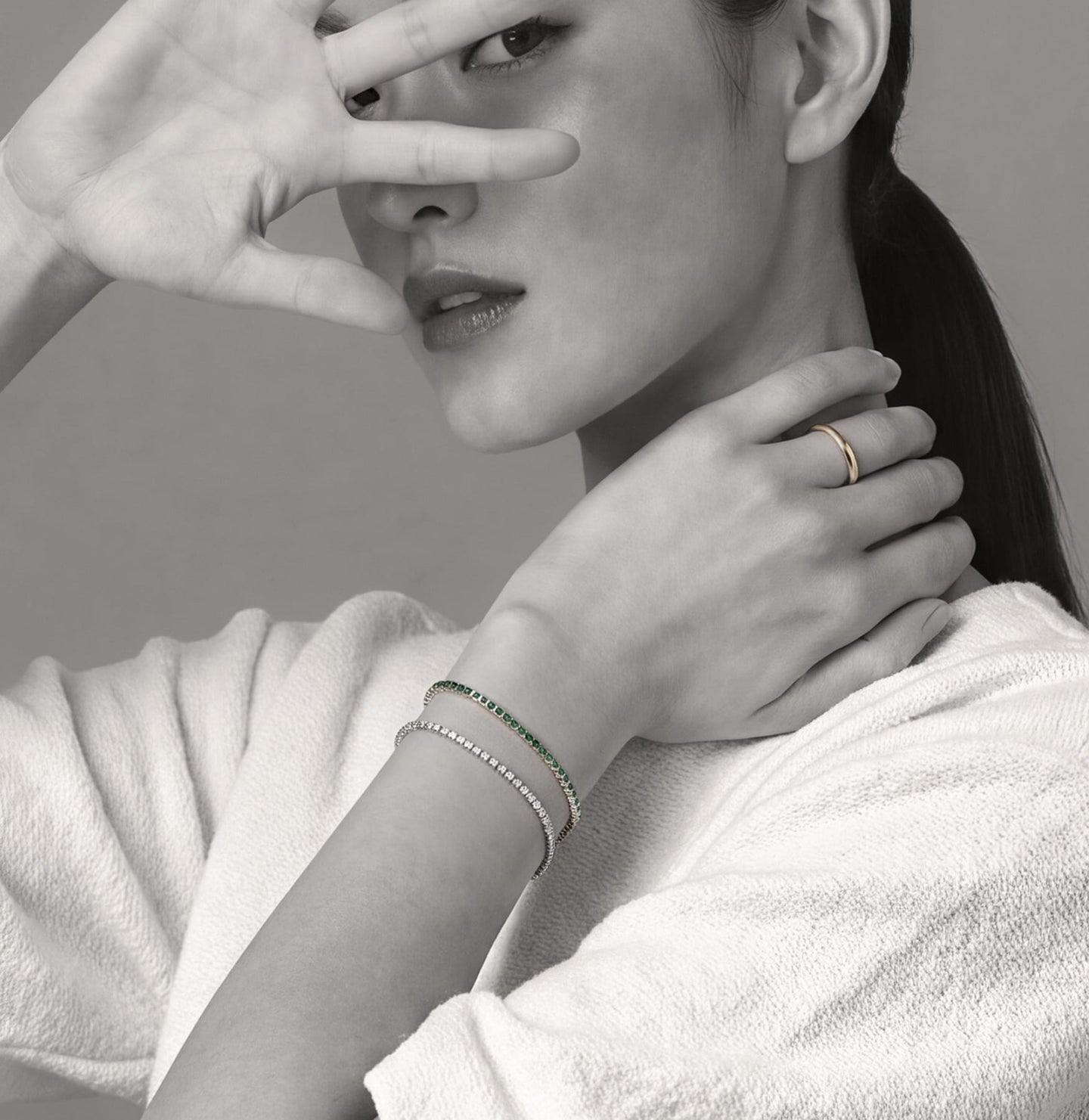 Miansai silver tone and green bracelets with a slim cuff worn on the wrist alongside a gold tone ring
