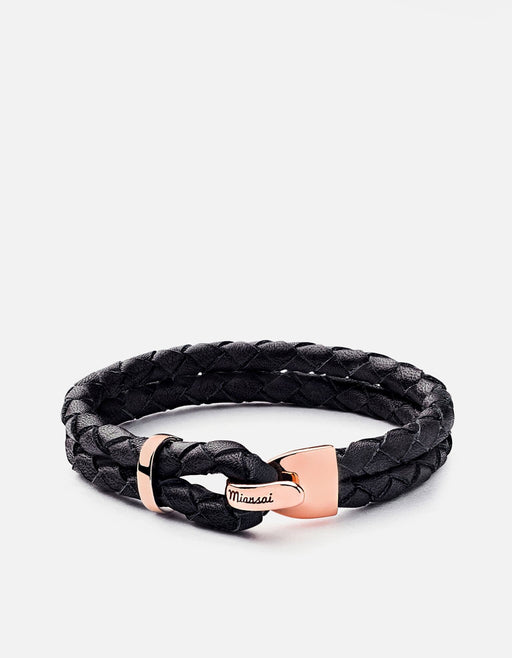 Miansai Beacon bracelet in black braided leather with rose gold plated hook closure shown fastened