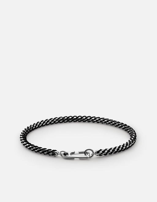 Miansai Annex braided chain bracelet in black rope with polished sterling silver clasp laid flat