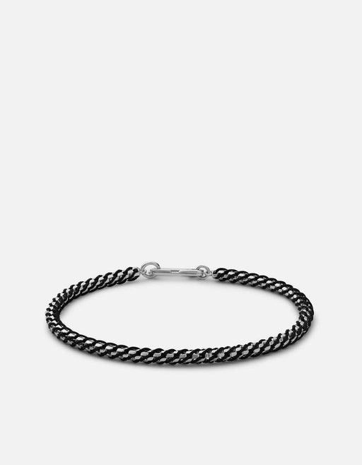 Miansai Annex braided bracelet in black rope woven with polished sterling silver chain and a silver clasp laid flat