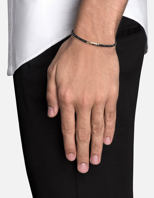 Miansai Juno rope bracelet in black nylon and steel with a gold vermeil spring clasp worn on the wrist