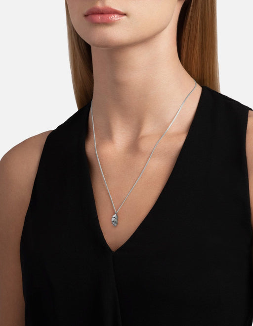 Miansai sterling silver lobster claw pendant necklace worn at the neck on a fine chain over a black sleeveless top