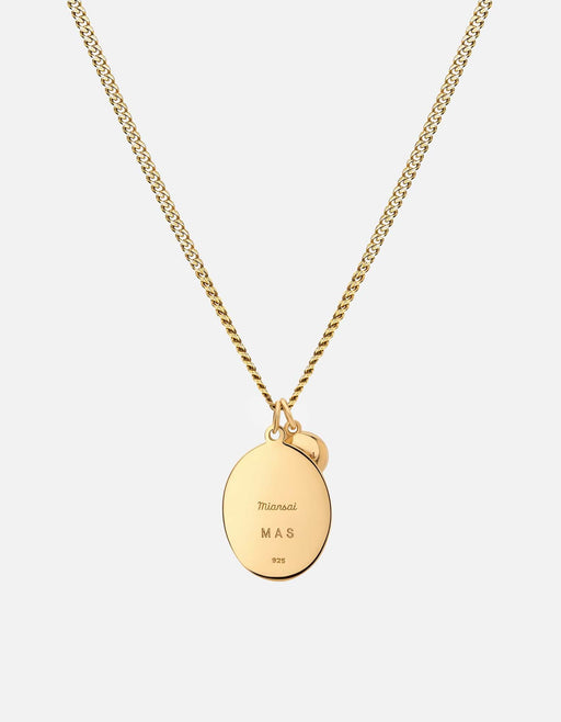Miansai Oxen pendant necklace in gold vermeil showing the engraved reverse of its oval medallion with a smaller round charm