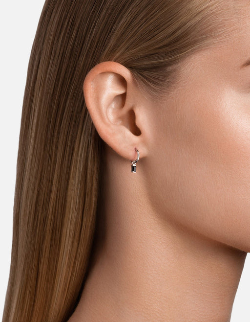 Miansai Valor huggie earring in sterling silver with a baguette-cut black onyx pendant worn on the earlobe