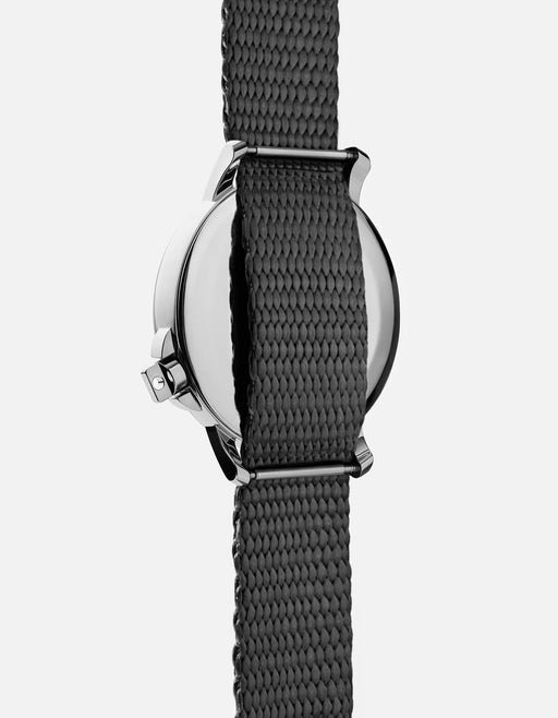 Miansai M12 Swiss watch in stainless steel with gray nylon strap, rear view showing polished caseback and woven strap texture