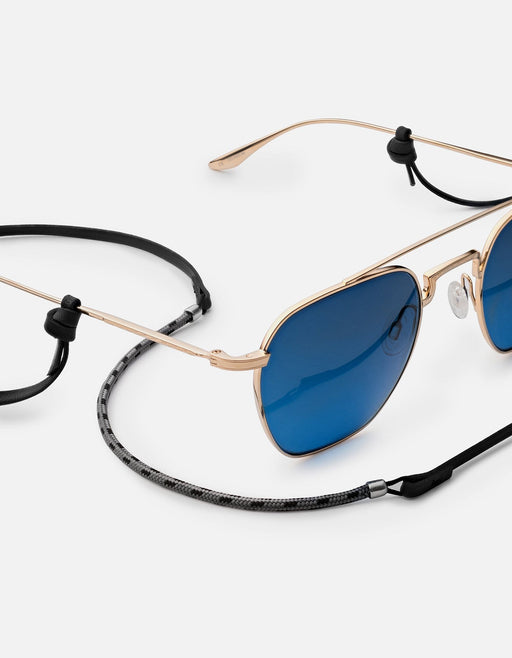 Miansai Nexus sunglass cord in black Italian leather and nylon rope with sterling silver finishes attached to blue lens sunglasses